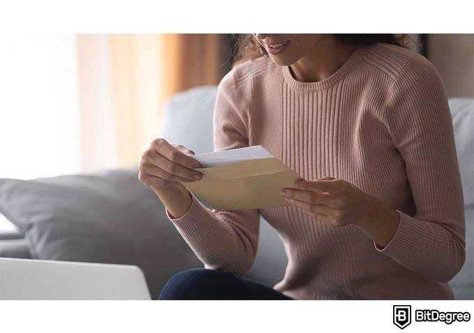 Mejores Cursos Alison: Mujer sosteniendo un sobre.